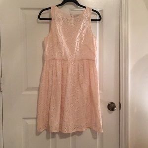 Pink and white eyelet dress with flower detail.